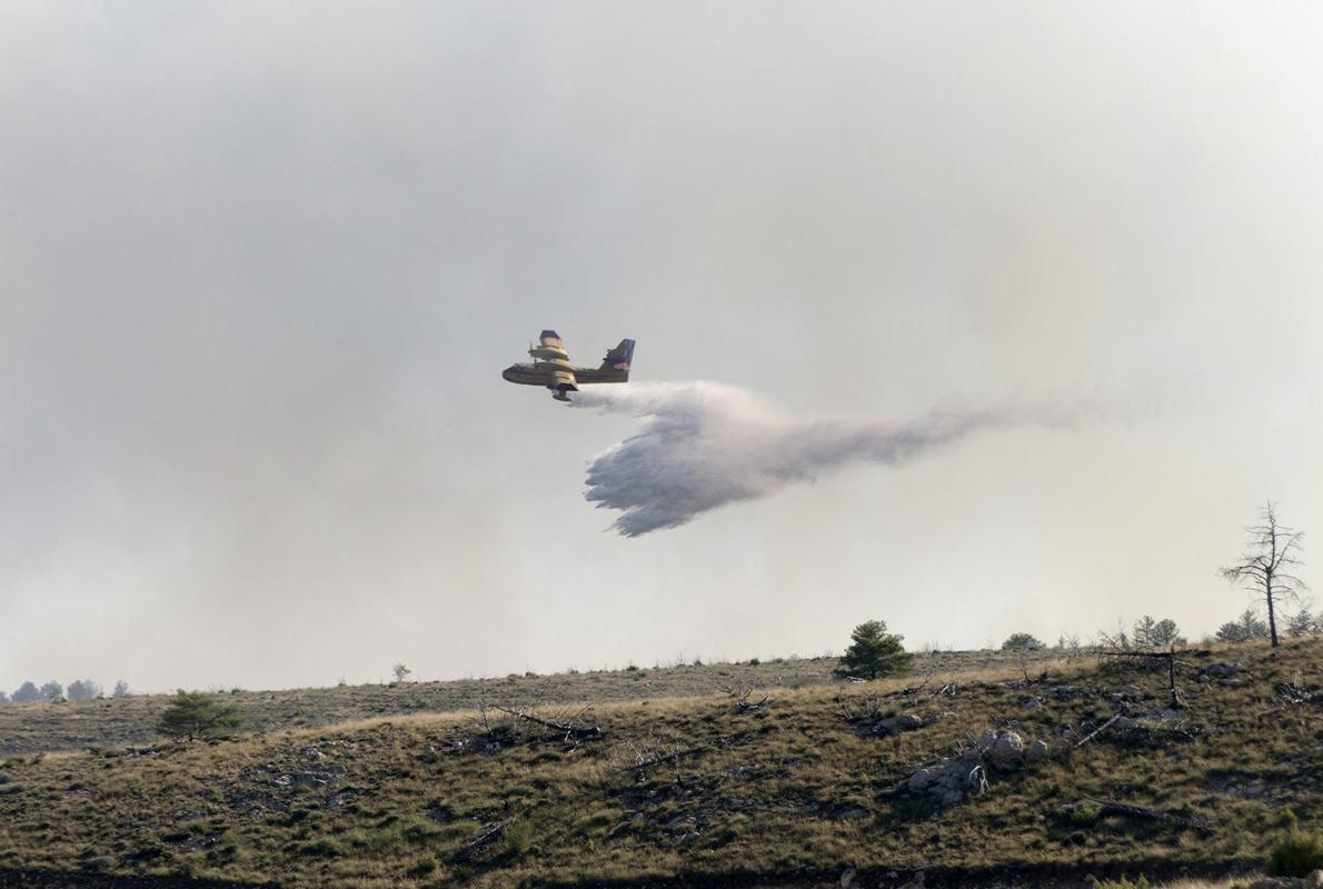 Un hidroavión echa agua para extinguir el incendio forestal declarado en Ejulve