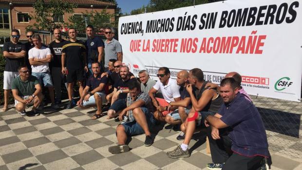 Los bomberos de Cuenca junto a la pancarta que han instalado en el Parque