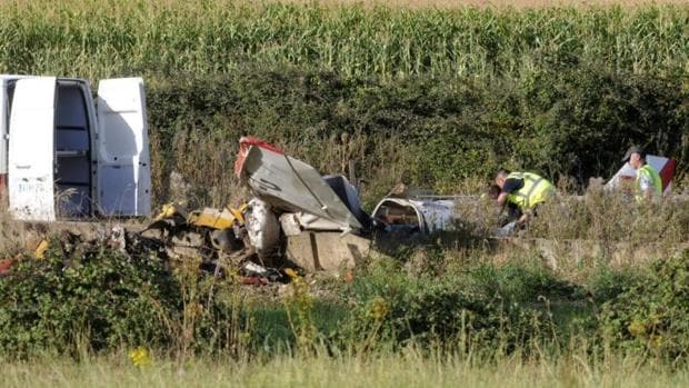 Dos guardias civiles investigan los restos de la avioneta que esta tarde se ha estrellado en una finca situada en las proximidades del Villanueva del Condado (León)