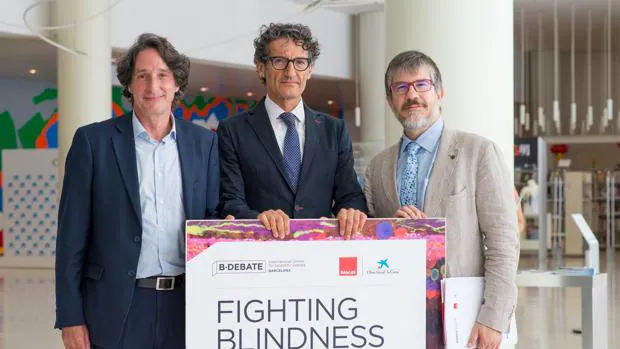 De izquierda a derecha, Jordi Portabella, director del Área de Investigación de La Caixa; Jordi Monés, director del Barcelona Macula Foundation; y Albert Barberà, director de Biocat, muestan el cartel de la jornada