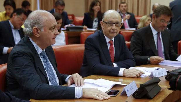 De Guindos (a la izquierda) y Catalá (a la derecha), durante la reunión de este lunes en el Congreso