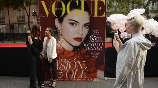 Dos chicas posan frente a una de las portadas de la revista Vogue