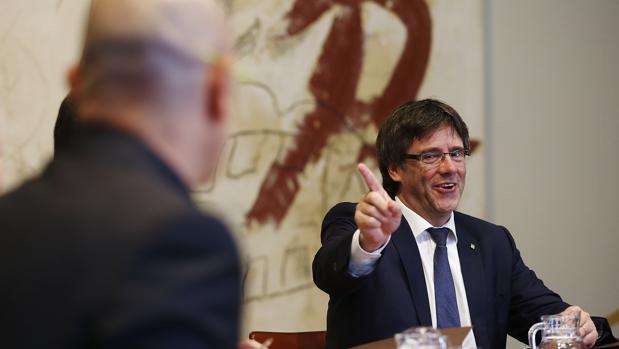 Puigdemont se dirige al consejero de Exteriores, Raül Romeva, duranta una reunión del gobierno catalán