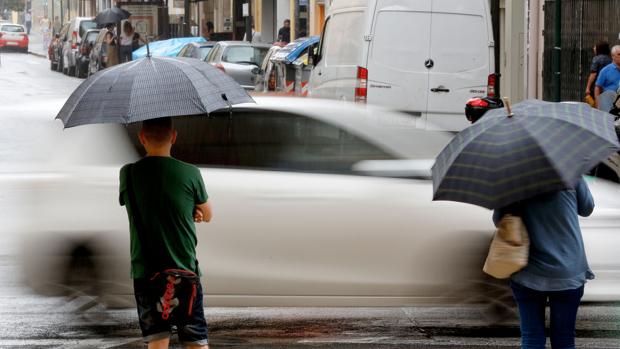 Dos personas se resguardan de la lluvia en el centro de Valencia