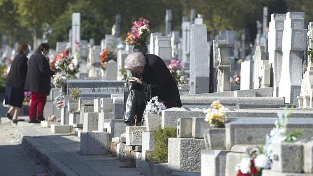 Varias mujeres visitan las tumbas del cementerio de la Almudena