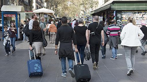 Un grupo de turistas pasea por la Rambla de Barcelona