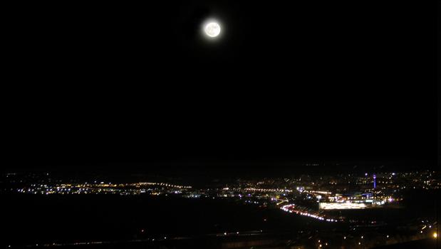 La superluna este lunes por la noche y, debajo, el Polígono de Toledo; la imagen está tomada desde la Biblioteca del Alcázar de Toledo