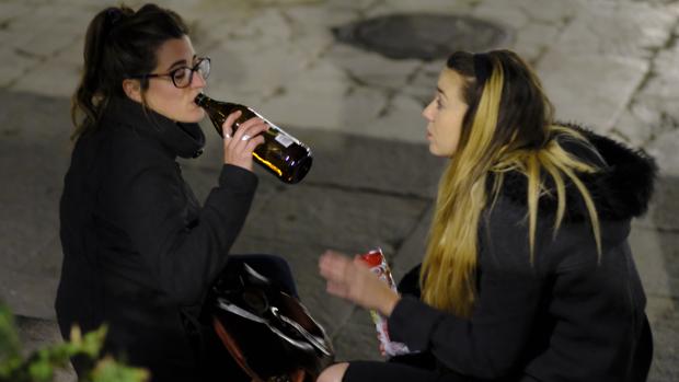 Dos jóvenes beben alcohol en la plaza del Dos de Mayo, en Malasaña