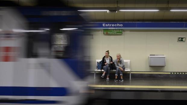 Dos viajeros esperan a que llegue el tren en la estación de metro de Estrecho