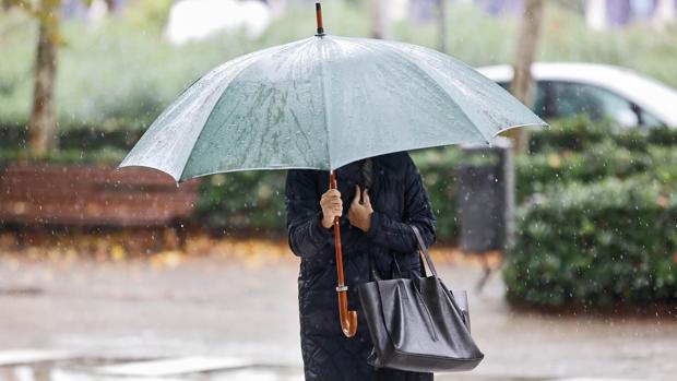 Una mujer se protege de la lluvia en Valencia