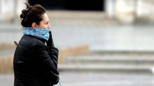 Imagen de archivo de una mujer protegiéndose del frío en Valencia