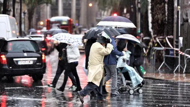Viandantes se protegen de la lluvia este viernes en la ciudad de Valencia