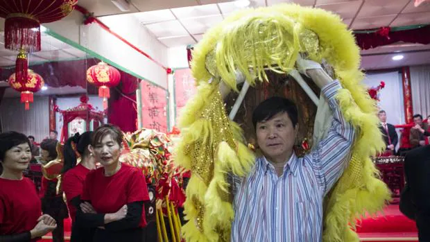 Un hombre se dispone a colocarse el traje de león para ensayar el desfile de la festividad del Año Nuevo Chino