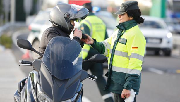 Un motorista sopla en un alcoholimetro durante un control de la Guardia Civil