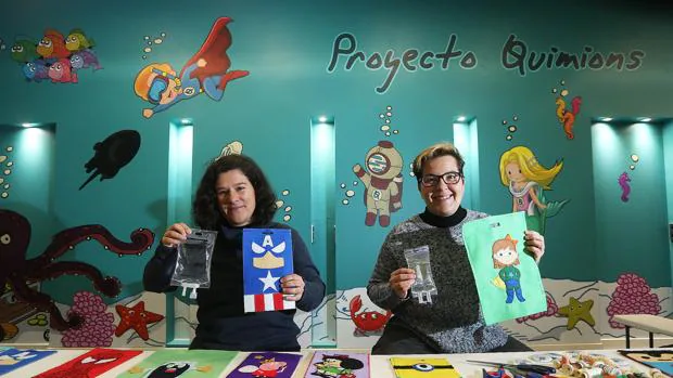 Rosa y Patricia muestran las bolsas de filetro que cubren los sueros y quimioterapias de los niños