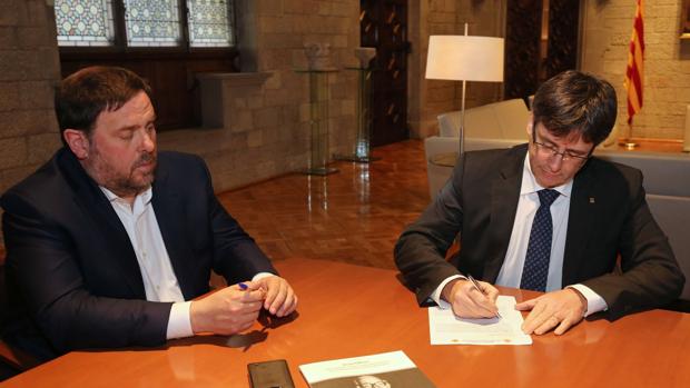 Puigdemont, junto a Junqueras, en el momento de firmar la notiificación del TC