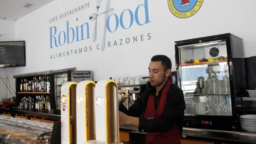 Un camarero sirve una cerveza en el restaurante «Robin Hood»