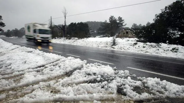 Un camión circula entre Alicante y Alcoy, con nieve alrededor