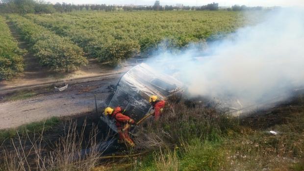 Los bomberos evacuan al conductor de un camión cargado de harina tras volcar en la A-7 en Picassent