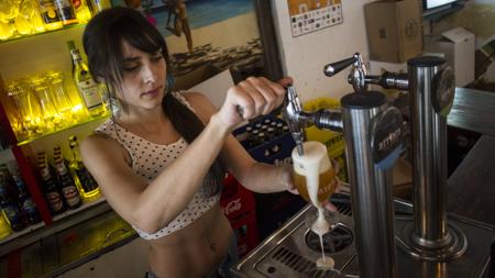 Silvia atiende tras la barra en La Playa de Lavapiés