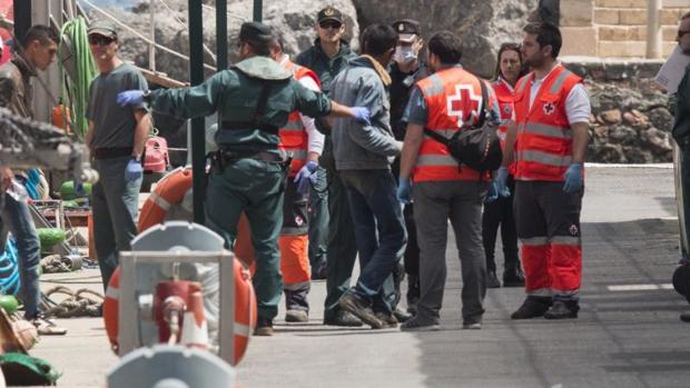 Agentes de la Guardia Civil y personal de Cruz Roja ayudan a bajar de la embarcación de Salvamar Denébola a 18 varones de origen magrebí