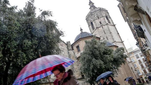 Transeúntes se protegen de la lluvia este jueves en València