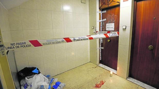 El piso donde se produjo el homicidio, con la puerta precintada, sangre y una vela