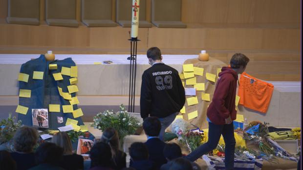 Dos compañeros rinden tributo a los fallecidos, en el Colegio Nuestra Señora del Recuerdo