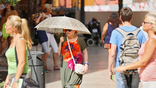 Una mujer se protege del calor en el centro de Valencia