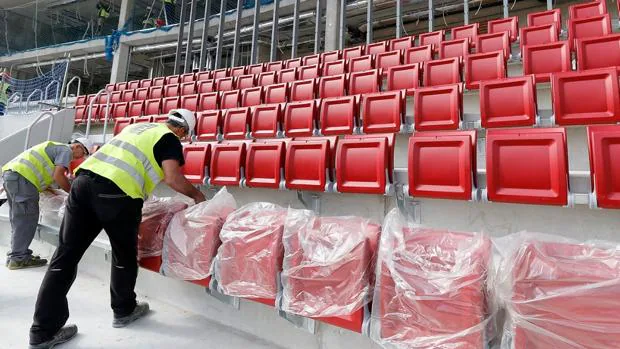 Los operarios colocan los asientos del nuevo estadio