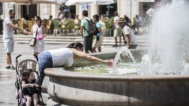 Una mujer se refresca en una fuente del centro de Valencia en una imagen de archivo