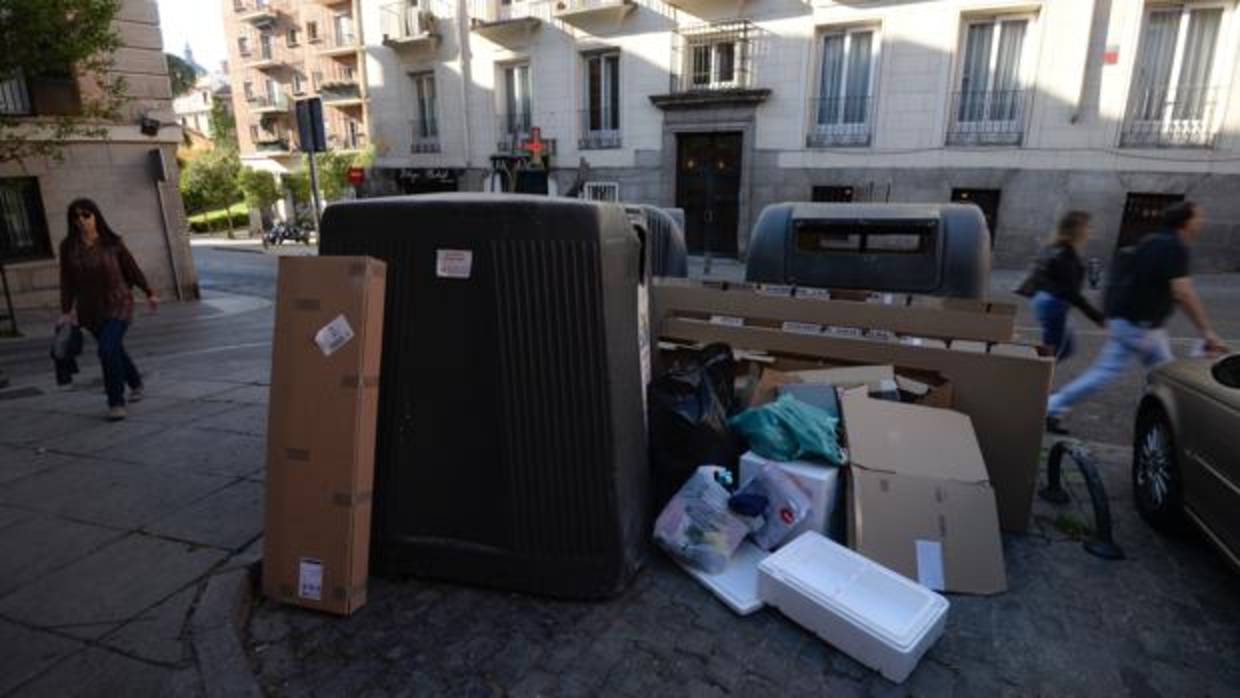 Basura acumulada alrdedor de unos contenedores, en el centro de la ciudad