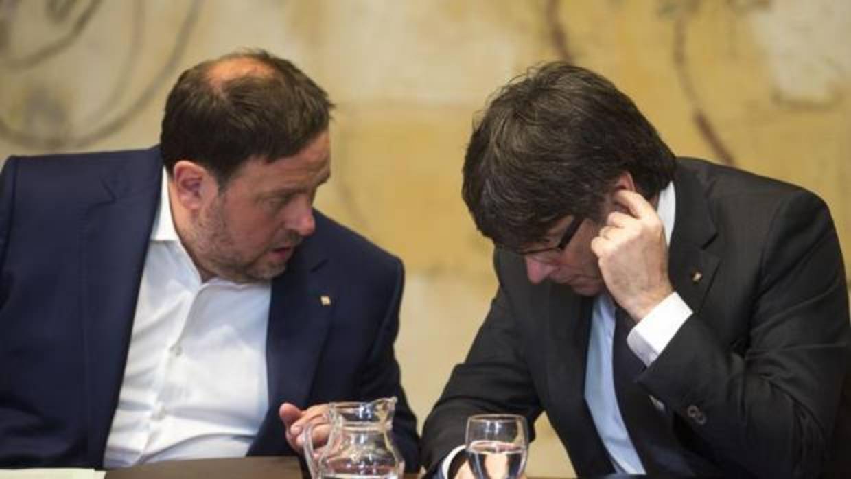 El presidente, de la Generalitat, Puigdemont, y el vicepresidente, Junqueras, durante una reunión del Ejecutivo