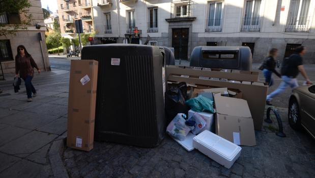Cartones y residuos alrededor de un contenedor en Madrid