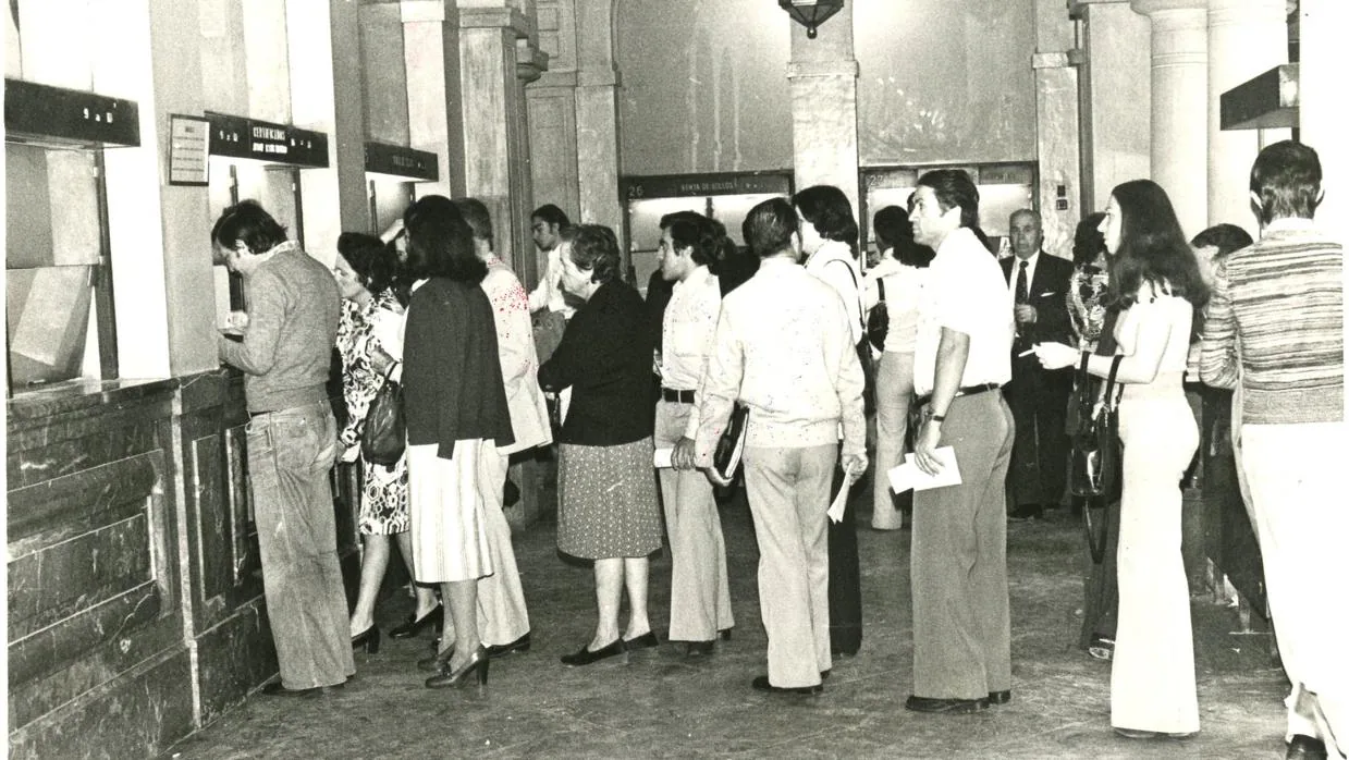 Ciudadanos haciendo cola ante las ventanillas de una oficina de Correos. La imagen es de 1977
