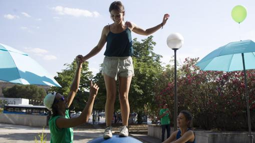 Una joven guarda el equilibrio encima de una pelota gigante