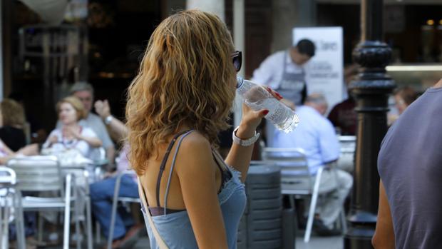 Una mujer bebe agua para hacer frente a las altas temperaturas