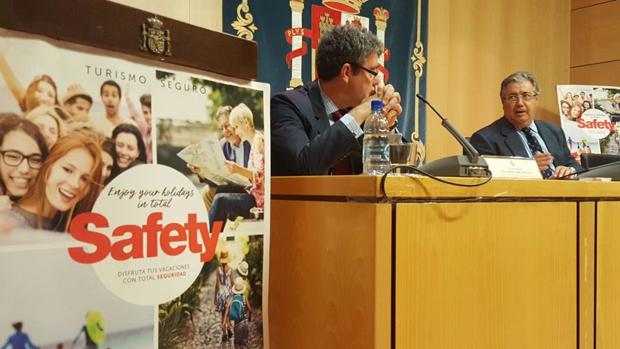 Los ministros Nadal y Zoido, este lunes, en la presentación de campaña de seguridad para turistas en verano