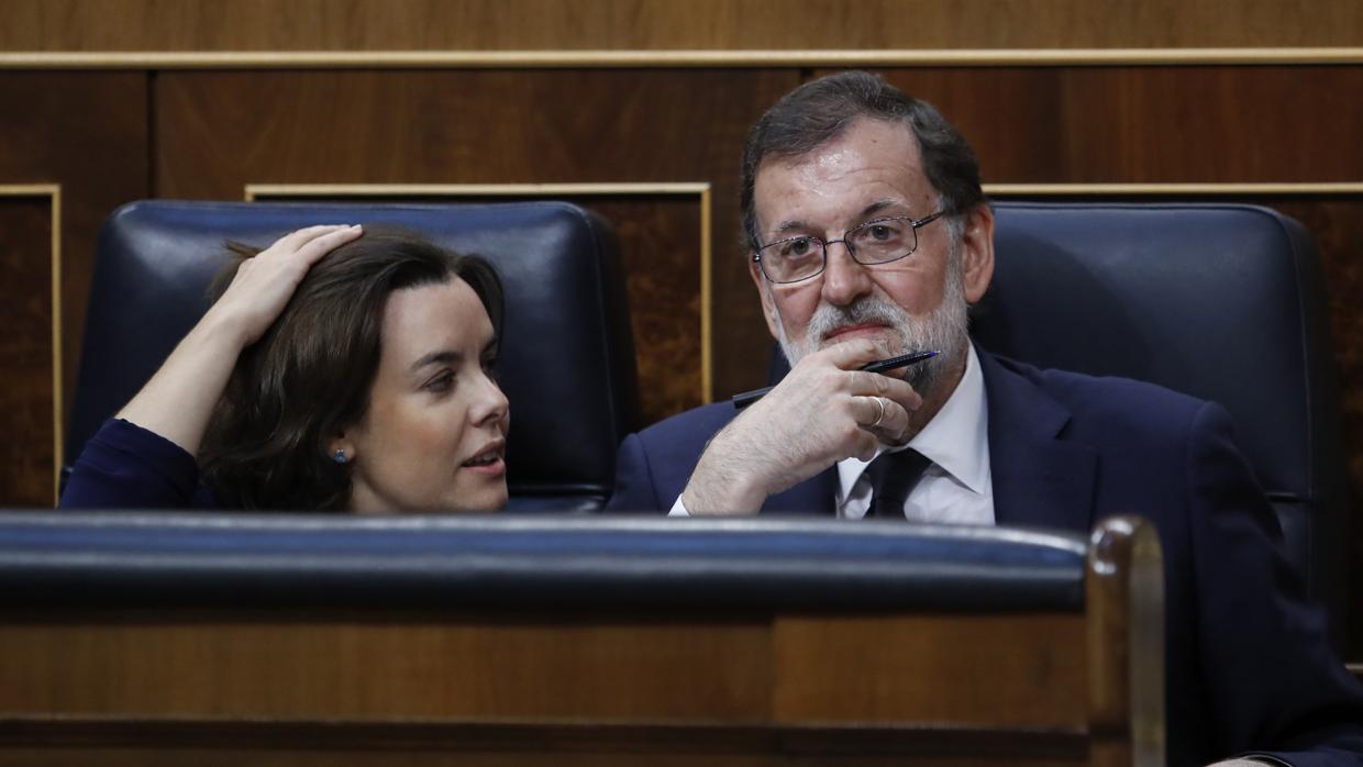 El presdiente del Gobierno Mariano Rajoy (dcha) junto a Soraya Sáenz de Santamaría en el Congreso