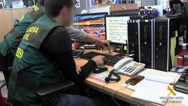 Dos guardias civiles analizan arhivos en un ordenador
