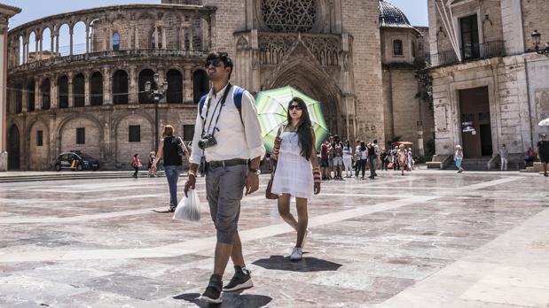 Unos turistas se protegen del calor en el centro de Valencia