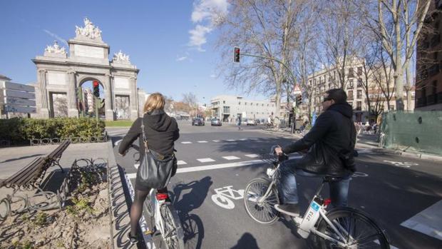 Dos ciclistas esperan en un semáforo de la capital