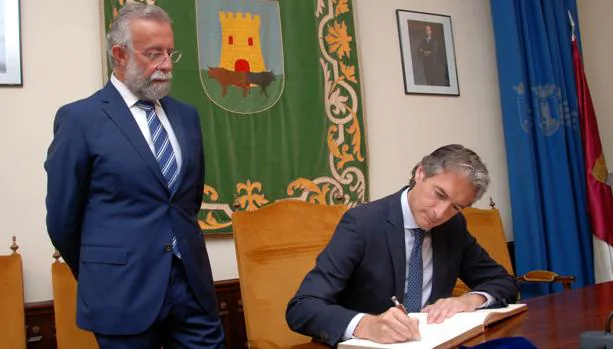 El ministro de Fomento, Íñigo de la Serna, firma en el libro de honor de Talavera de la Reina en presencia del alcalde, Jaime Ramos