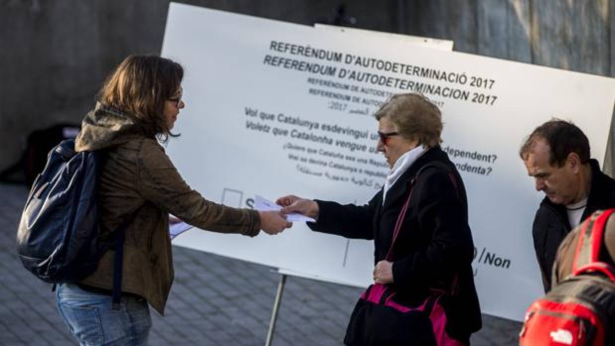 Una diputada de la CUP reparte papeletas en una campaña para un eventual referéndum de independencia en Cataluña