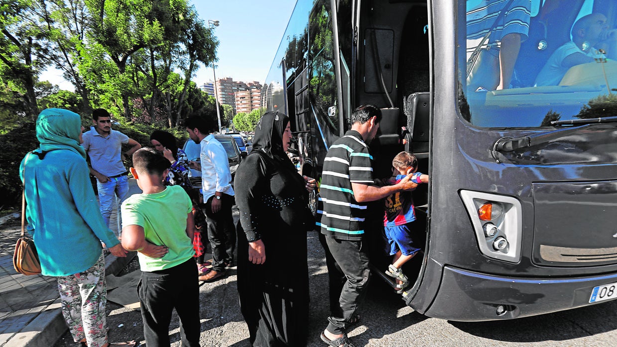 Varios refugiados esuben ayer por la tarde a un autobús para su traslado