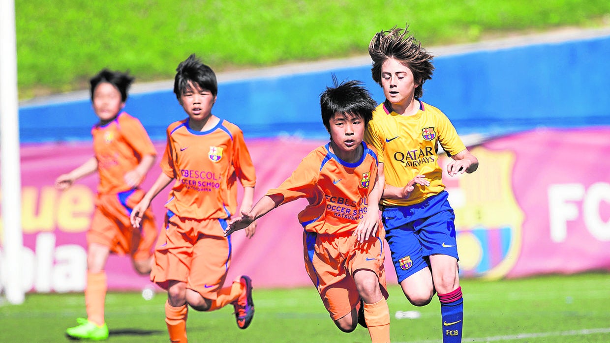 Varios niños de una Escuela asiática del Barcelona disputan un partido