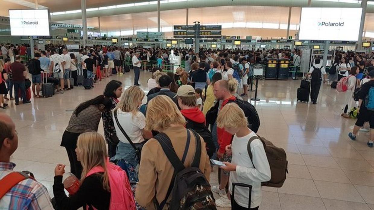 Viajeros esperando pasar los controles del aereopuerto de Barcelona-El Prat