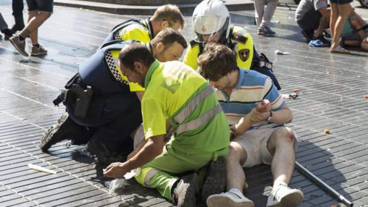 Los servicios de emergencias atienden a varios de los heridos tras el atentado en las Ramblas de Barcelona