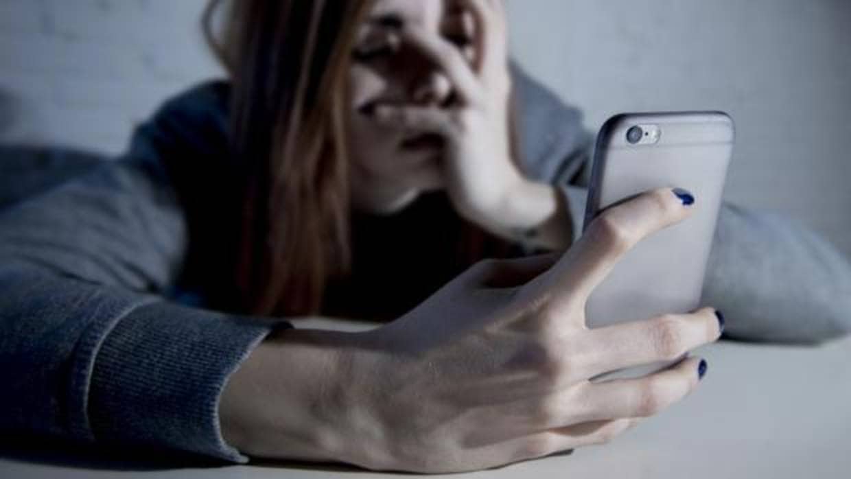 Una adolescente leyendo mensajes en su móvil
