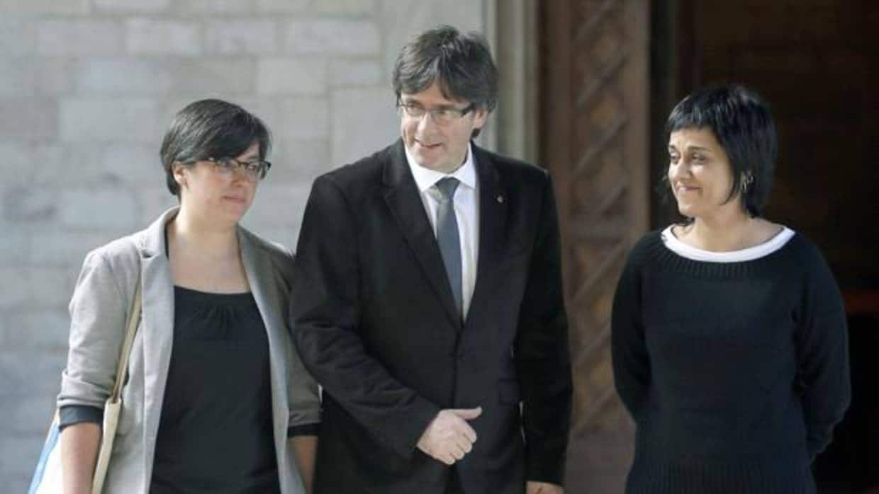 Carles Puigdemont en medio de Mireia Boya (i) y Anna Gabriel (d)